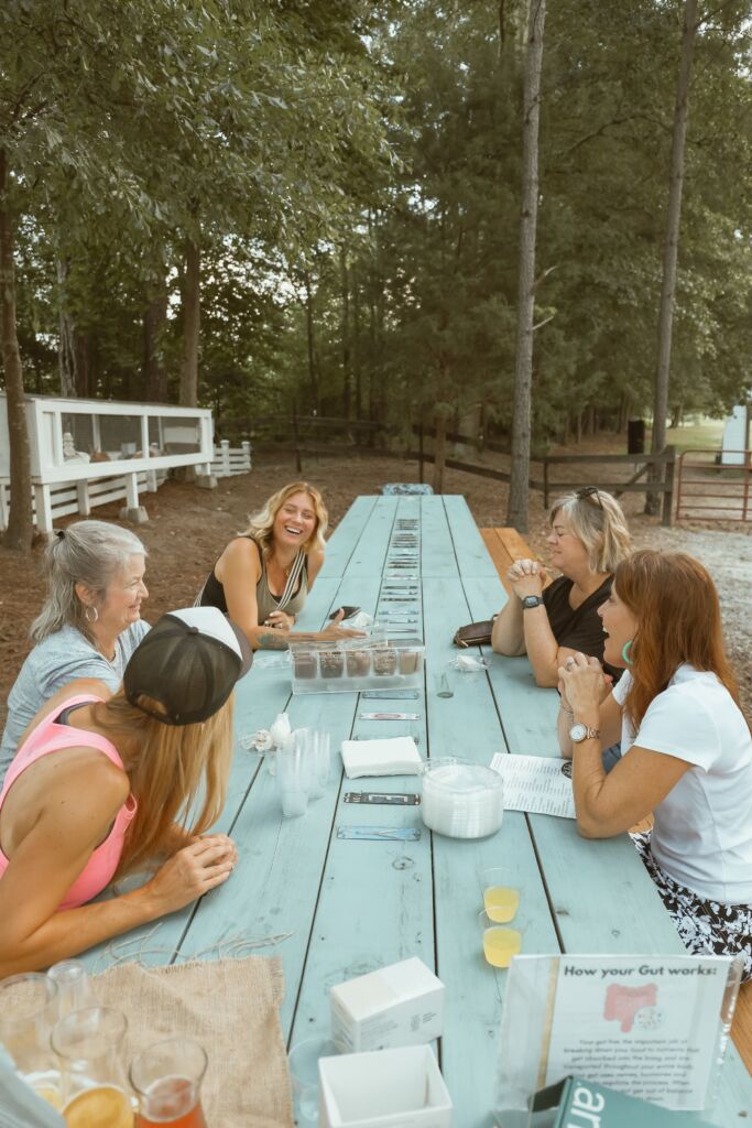 5 women seated at a picnic table at Marie Farms